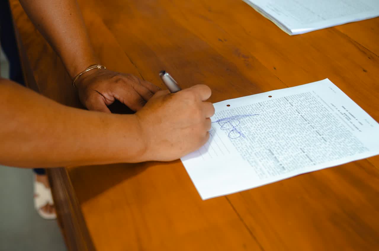 Hands signing a contract